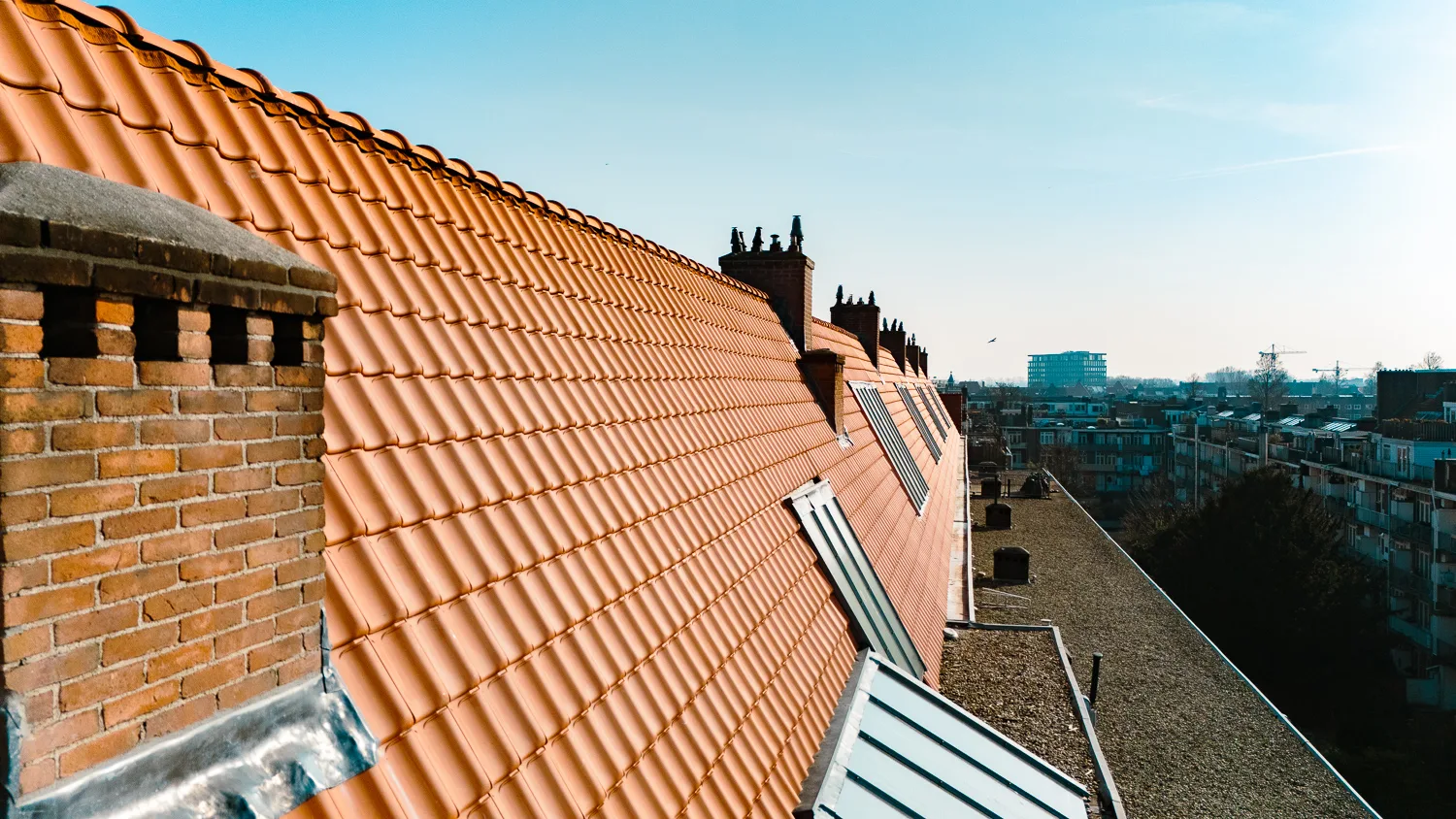 Schoorsteen en nieuwe oranje dakpannen aan het Legmeerplein