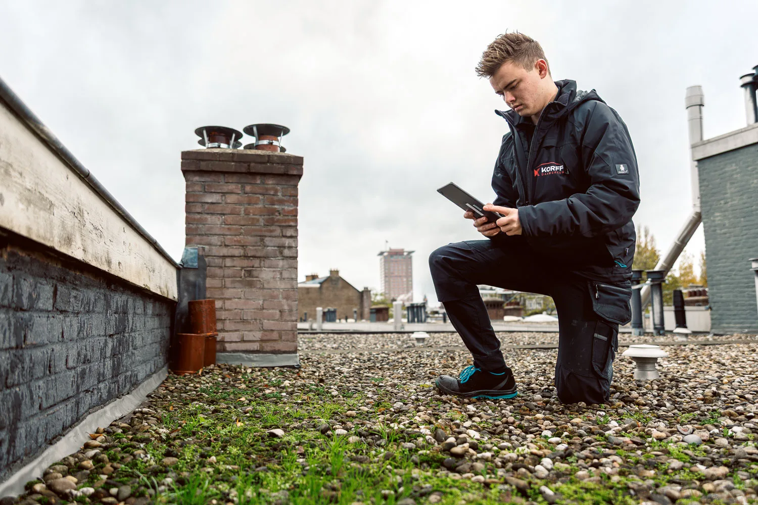 Servicemonteur van Korff inspecteert een plat dak met tablet